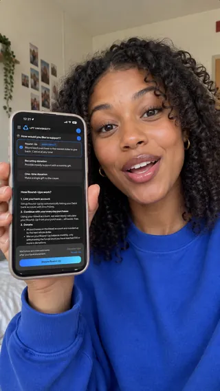Ambassador content mockup of a student in a blue sweatshirt showing the giving screen in a dorm room.