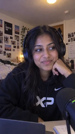 Ambassador content mockup of a student wearing an XtraPoint hoodie at a desk with a microphone.