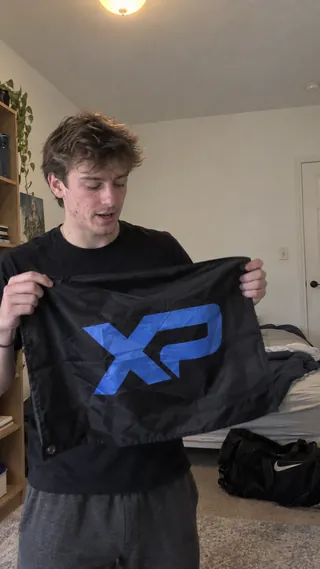 Ambassador content mockup of a student displaying an XtraPoint flag in a bedroom.
